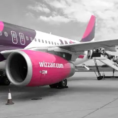 Samolot Wizzair na płycie lotniska. Pasażerowie wsiadają po schodkach. Zastanawiasz się, jak odwołać lot Wizzair?