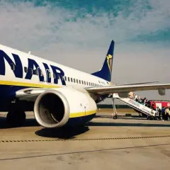 Ryanair samolot na płycie lotniska, pasażerowie wsiadają po schodkach. Tanie loty z Łodzi czekają!