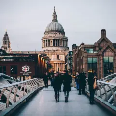 Most ludzi na moście Millennium Bridge w Londynie, z widokiem na katedrę św. Pawła.