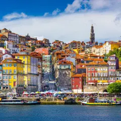 Kolorowe kamienice Porto nad rzeką, z widokiem na wieżę i kościoły. Marzenie o lotach z Gdańska do Porto.