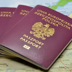 Trzy polskie paszporty leżą na mapie. Zastanawiasz się, ile trwa wyrobienie paszportu?