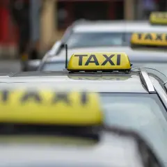Rząd żółtych taksówek z napisem "TAXI" na dachach.