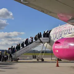 Pasażerowie wsiadają po schodkach do samolotu Wizz Air.