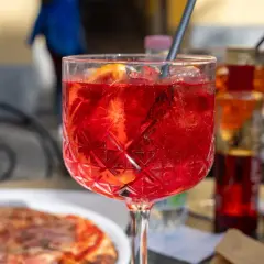 Orzeźwiający Aperol Spritz z plastrem pomarańczy, idealny na aperitivo. Pytasz gdzie zjeść w Mediolanie? To może być początek Twojej kulinarnej podróży!