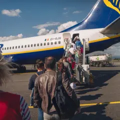 Ludzie wchodzą po schodkach do samolotu Ryanair. Czas na odprawę!