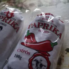 Dwie paczki mielonej papryki z Węgier, jedna z rysunkiem kobiety z koszykiem, druga z papryczką.