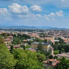 Widok na Bergamo z licznymi dachami i zielenią, idealne miejsce na loty do Bergamo.