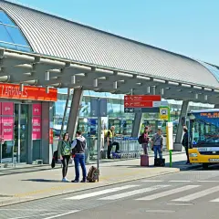 Autobus z napisem "Stacja Modlin" czeka na pasażerów. To dobry sposób, jak dojechać na lotnisko Modlin.