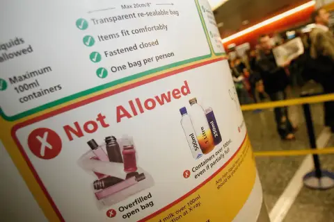 Na tablicy informacyjnej widać zasady dotyczące przewozu płynów. Maksymalnie ile ml można do samolotu to 100ml w pojemnikach.