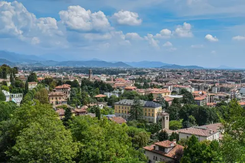 Widok na Bergamo z licznymi dachami i zielenią, idealne miejsce na loty do Bergamo.