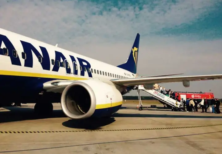 Ryanair samolot na płycie lotniska, pasażerowie wsiadają po schodkach. Tanie loty z Łodzi czekają!