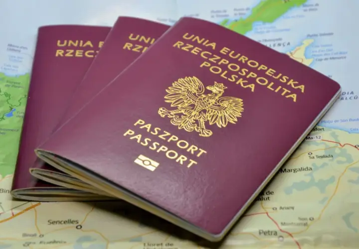 Trzy polskie paszporty leżą na mapie. Zastanawiasz się, ile trwa wyrobienie paszportu?