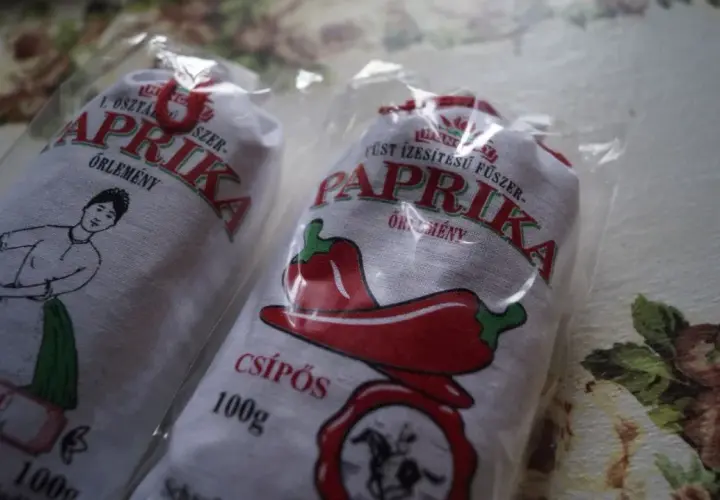 Dwie paczki mielonej papryki z Węgier, jedna z rysunkiem kobiety z koszykiem, druga z papryczką.