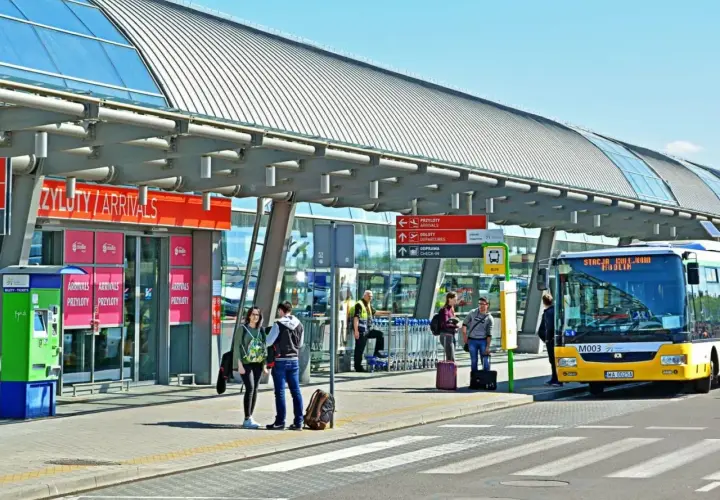 Autobus z napisem "Stacja Modlin" czeka na pasażerów. To dobry sposób, jak dojechać na lotnisko Modlin.