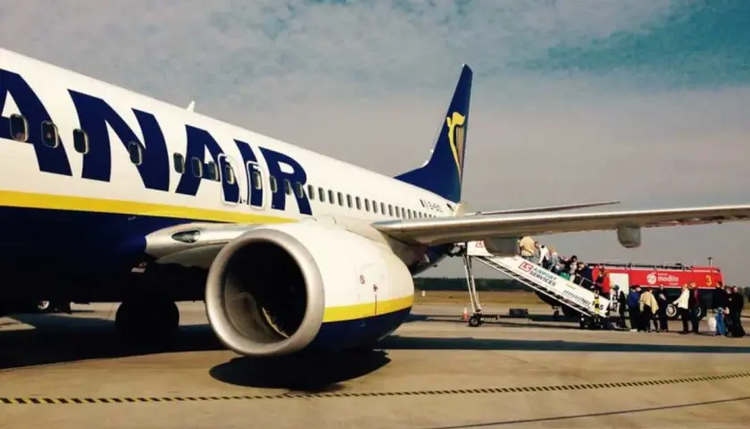 Ryanair samolot na płycie lotniska, pasażerowie wsiadają po schodkach. Tanie loty z Łodzi czekają!