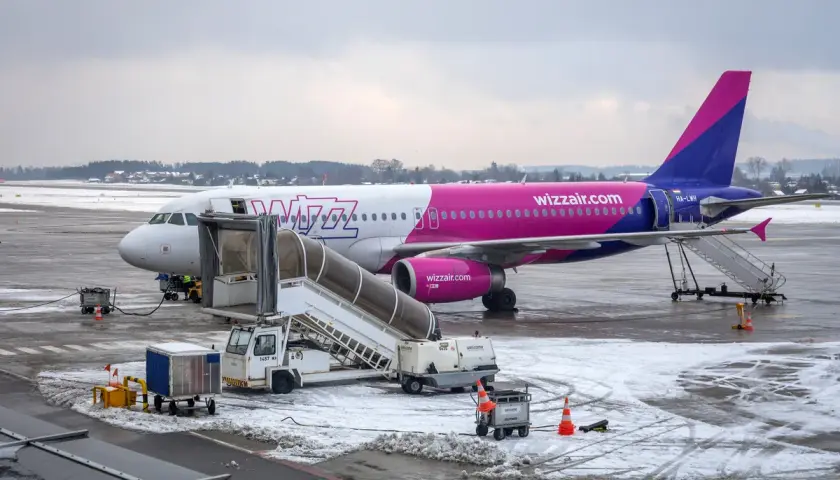 Samolot Wizz Air na lotnisku zimą. Zastanawiasz się, ile się płaci za nadbagaż Wizzair? Sprawdź przed podróżą!