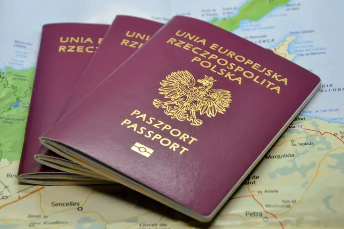 Trzy polskie paszporty leżą na mapie. Zastanawiasz się, ile trwa wyrobienie paszportu?