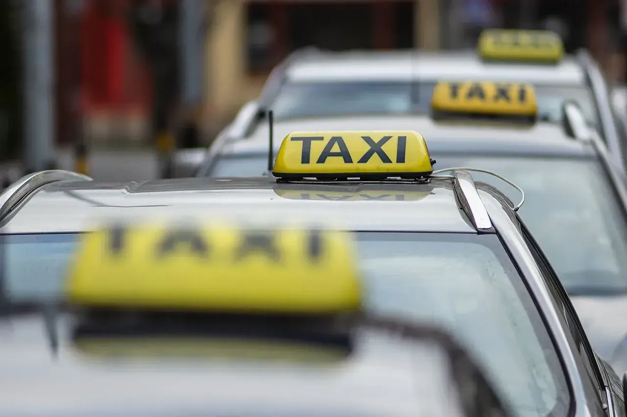 Rząd żółtych taksówek z napisem "TAXI" na dachach.