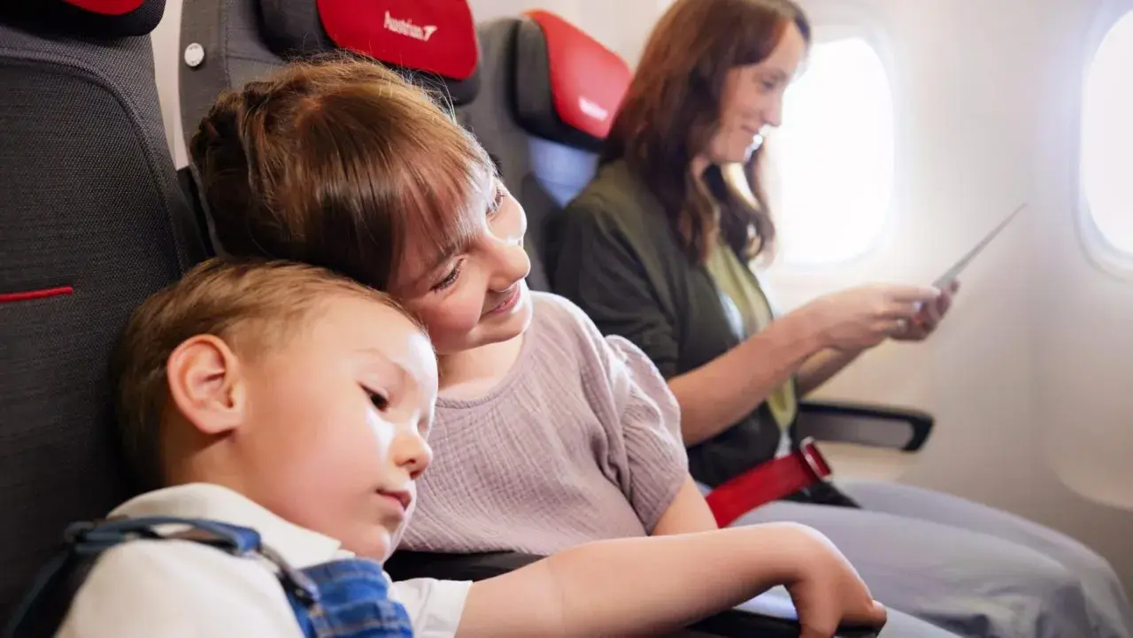 Dzieci śpią i siedzą obok mamy w samolocie. Dowiedz się, jak dodać dziecko do rezerwacji Ryanair.