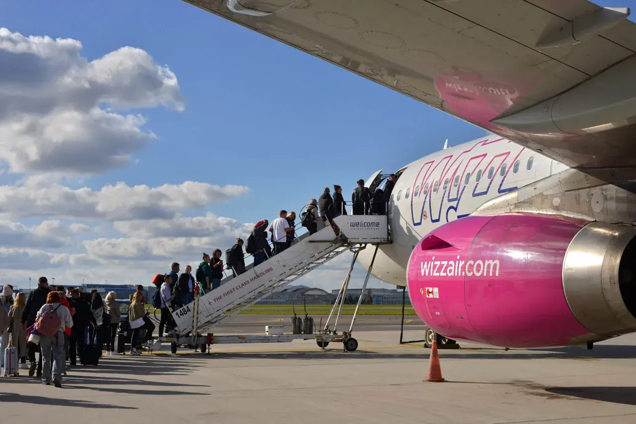 Pasażerowie wsiadają po schodkach do samolotu Wizz Air.
