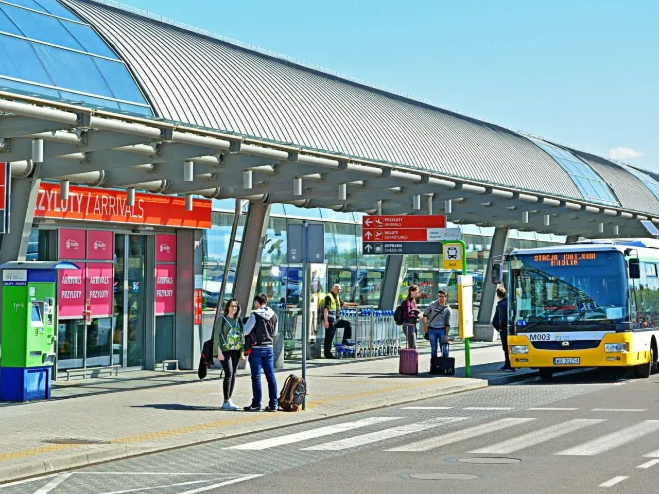 Autobus z napisem "Stacja Modlin" czeka na pasażerów. To dobry sposób, jak dojechać na lotnisko Modlin.