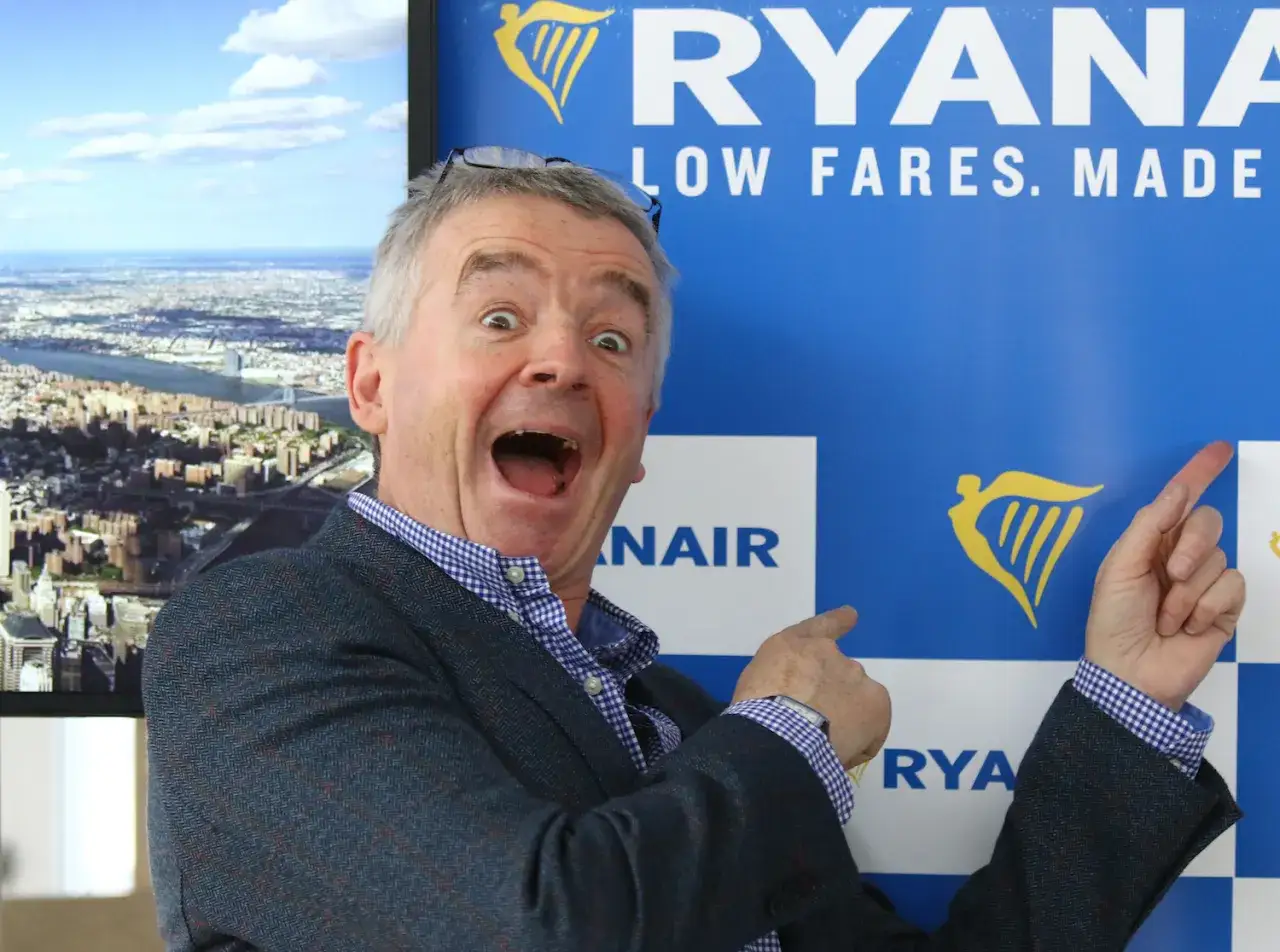 Michael O'Leary, znany jako właściciel Ryanaira, wskazuje na logo linii lotniczych.