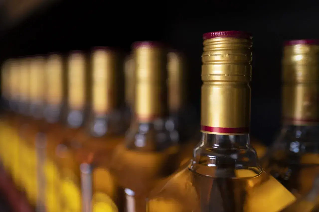 Rząd złotych butelek z alkoholem, zastanawiasz się, ile można przewieźć alkoholu w samolocie?