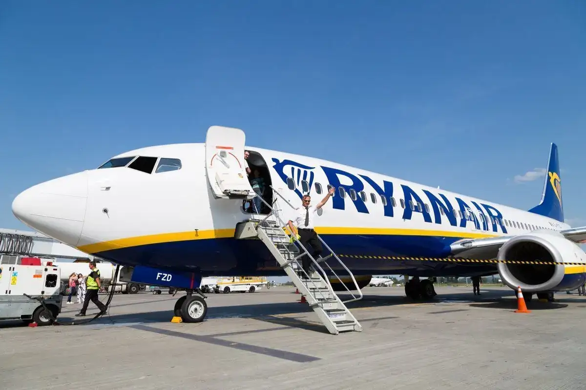 Pilot Ryanair wita pasażerów przy schodkach samolotu. Chcesz wiedzieć, jak zmienić rezerwację w Ryanair?