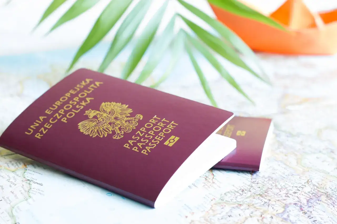 Dwa polskie paszporty leżą na mapie, gotowe do podróży. Zastanawiasz się, ile trwa wyrobienie paszportu?