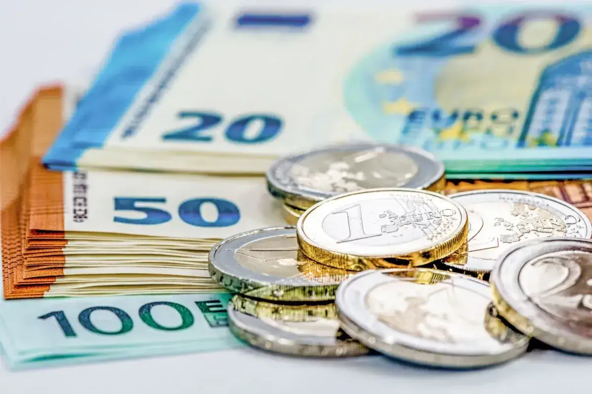 Stos banknotów 100, 50 i 20 euro oraz monety. Zastanawiasz się, ile gotówki można przewieźć samolotem?