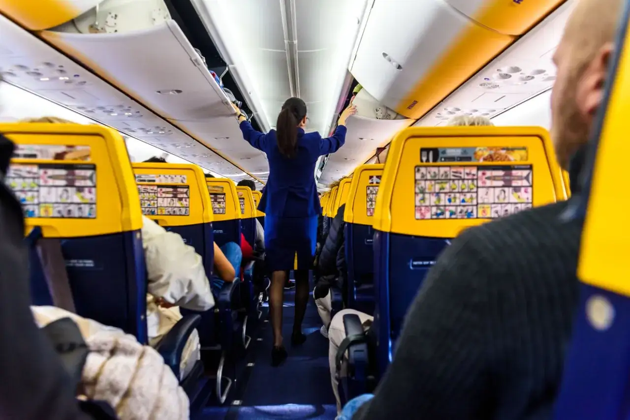 Stewardessa w samolocie Ryanair pomaga pasażerom, gdy zastanawiasz się, jak zmienić rezerwację.