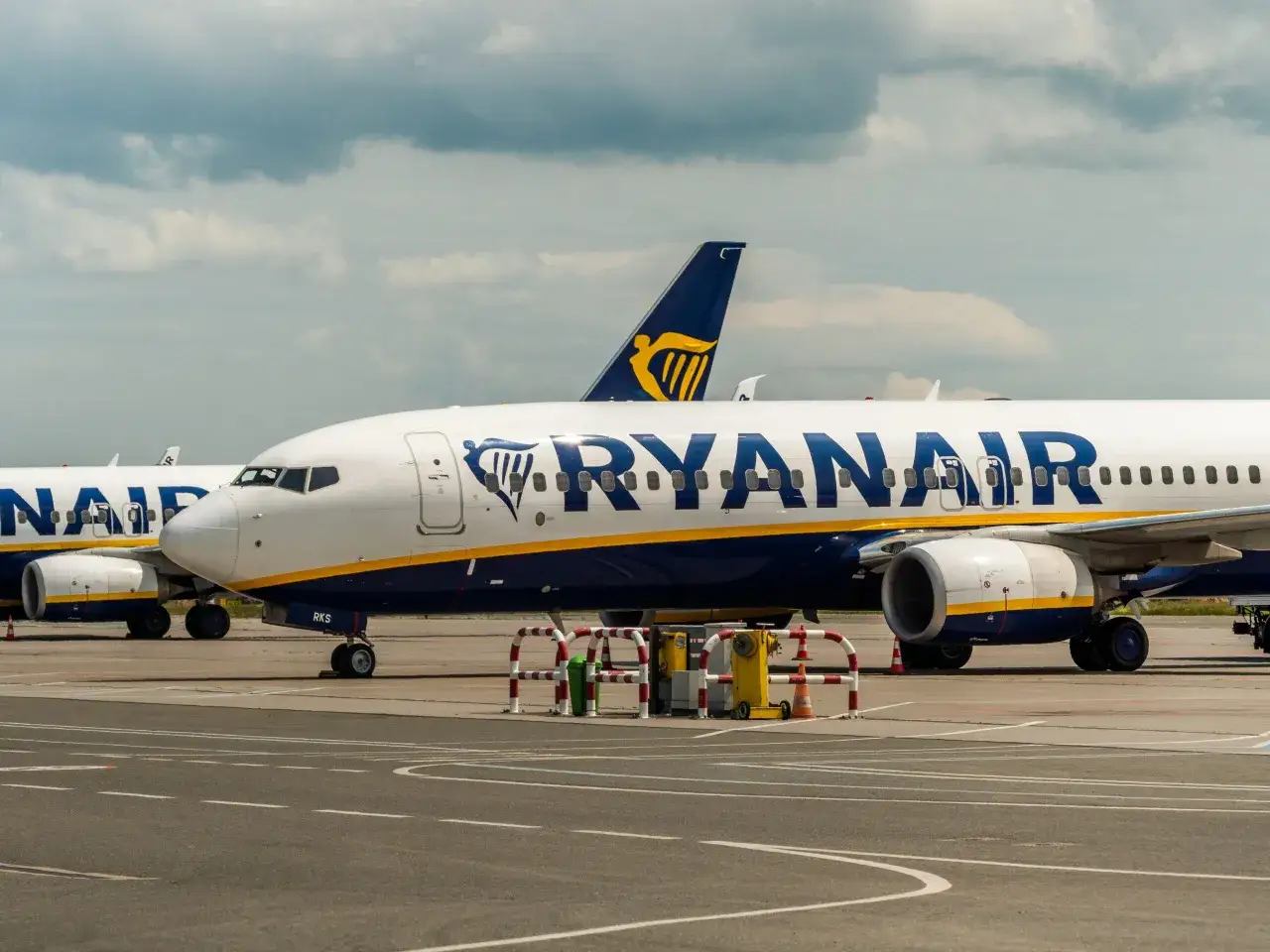 Samoloty Ryanair na płycie lotniska. Planujesz podróż i zastanawiasz się, jak dodać dziecko do rezerwacji Ryanair?