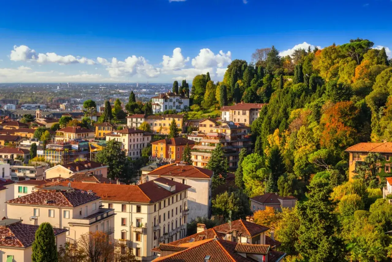 Widok na wzgórza Bergamo, gdzie jesienne liście mienią się kolorami. Idealne miejsce na loty do Bergamo.