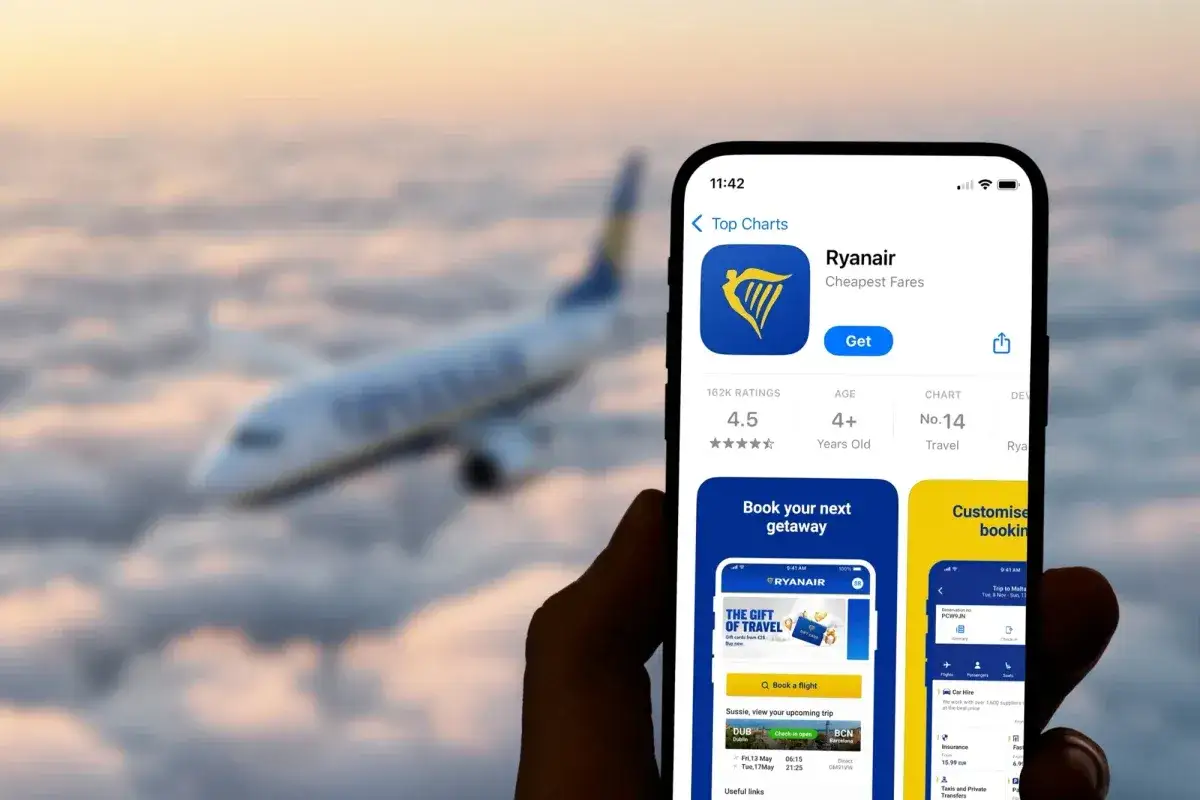 Aplikacja Ryanair na telefonie, z samolotem w tle. Sprawdzam, czy trzeba wydrukować kartę pokładową.